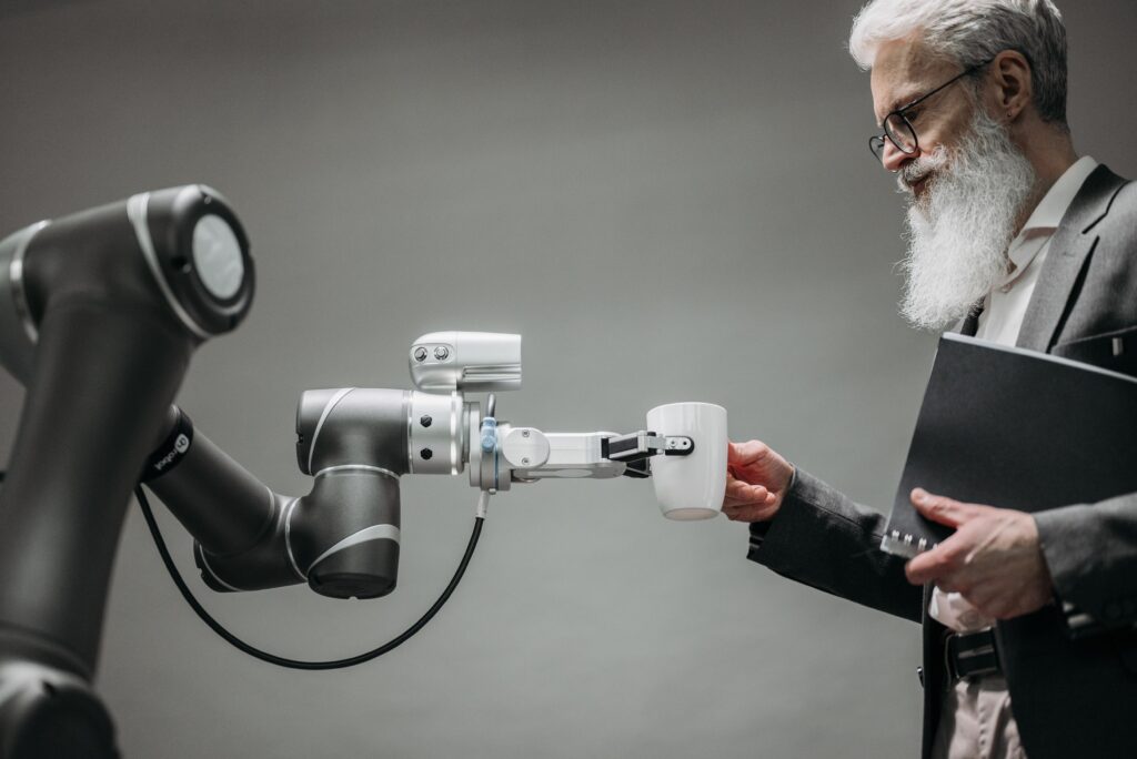 A robotic arm handing a cup to a professional, representing AI and human collaboration in an AI-ready hiring process